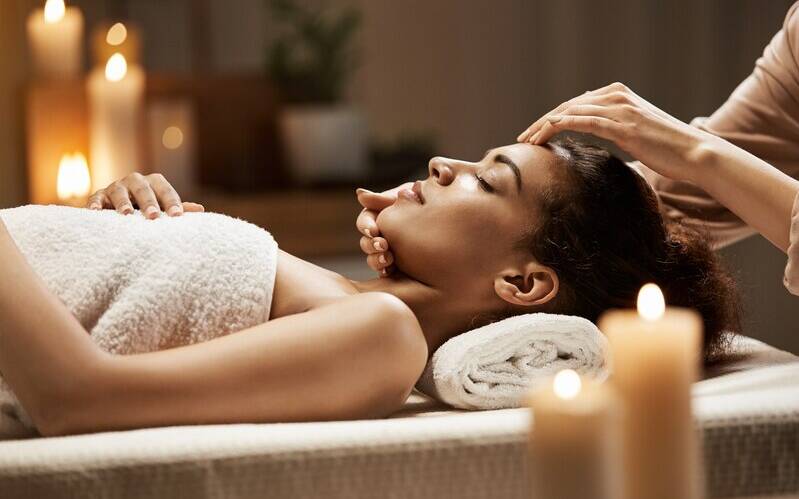 attractive-african-woman-enjoying-face-massage-spa-salon_176420-13955